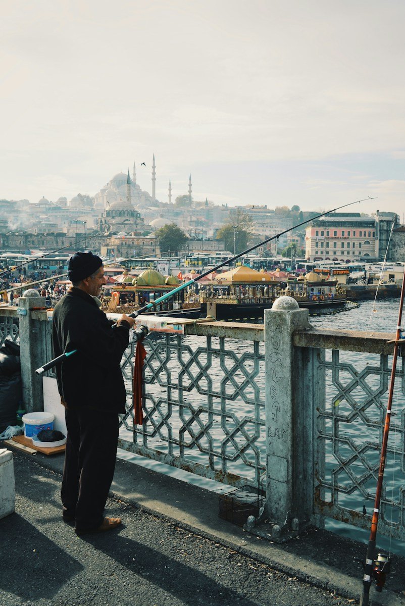 man fishing using black and blue fishing rod